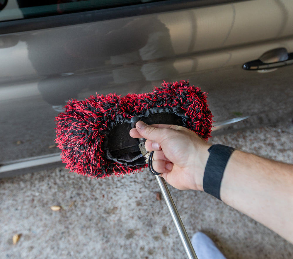 Brush Cover en microfibre noire et rouge fixé sur la tête d’une brosse de lavage