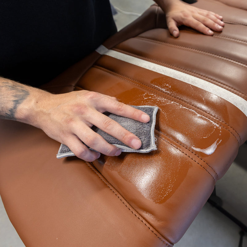 Nettoyage d’un siège en cuir brun avec un Scrub Pad.