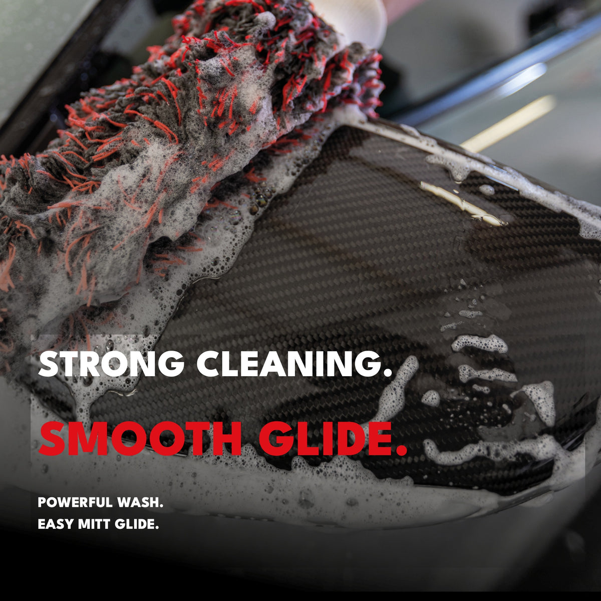 Wash mitt cleaning a carbon-fibre car panel with Wash & Snow Foam shampoo for strong cleaning and smooth glide.