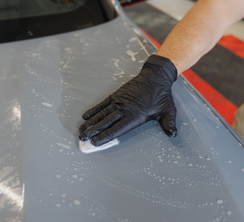 Argile de décontamination guidée à la main sur une peinture imprégnée de lubrifiant