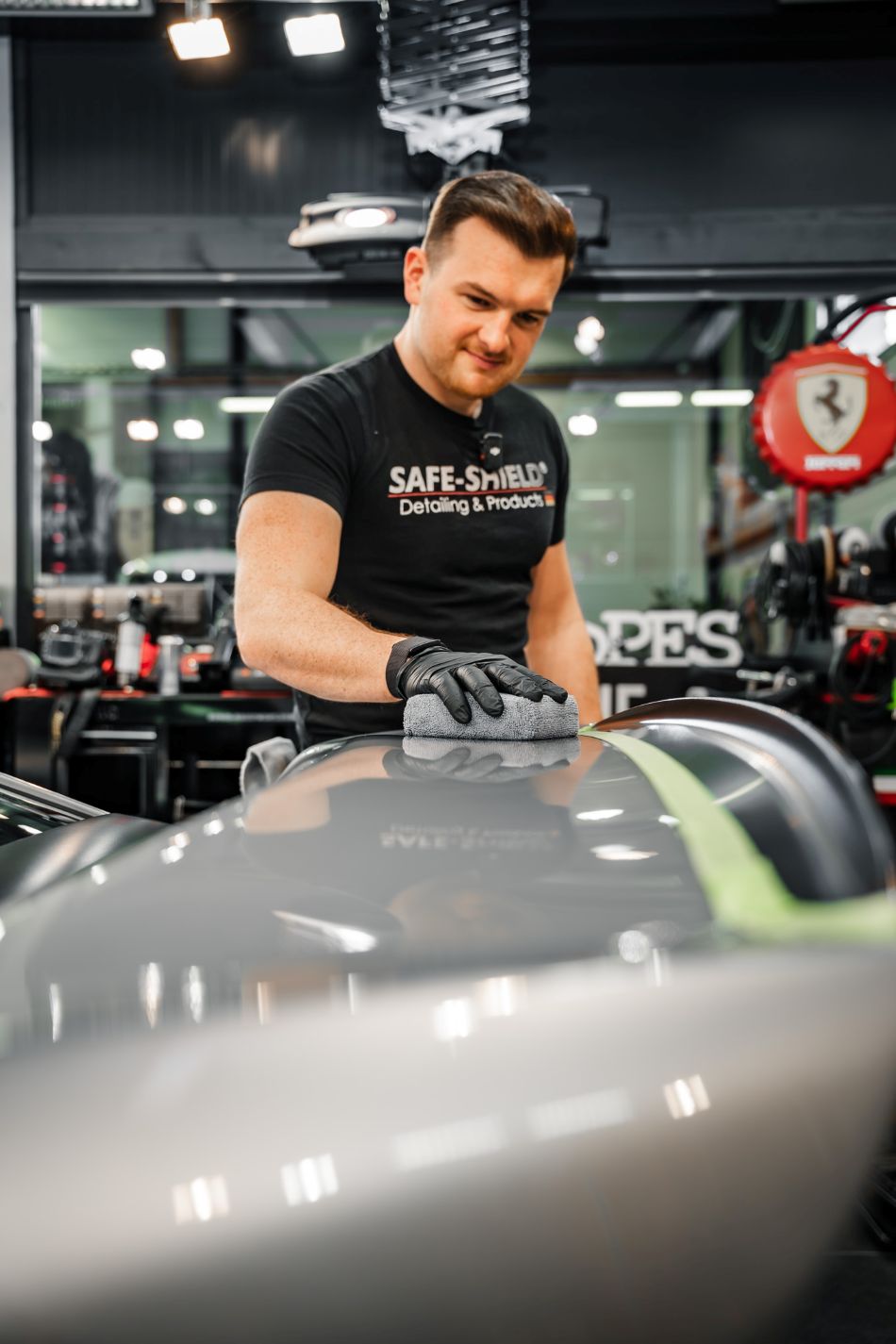 Tim brengt met de microvezelapplicator een coating aan op grijze autolak