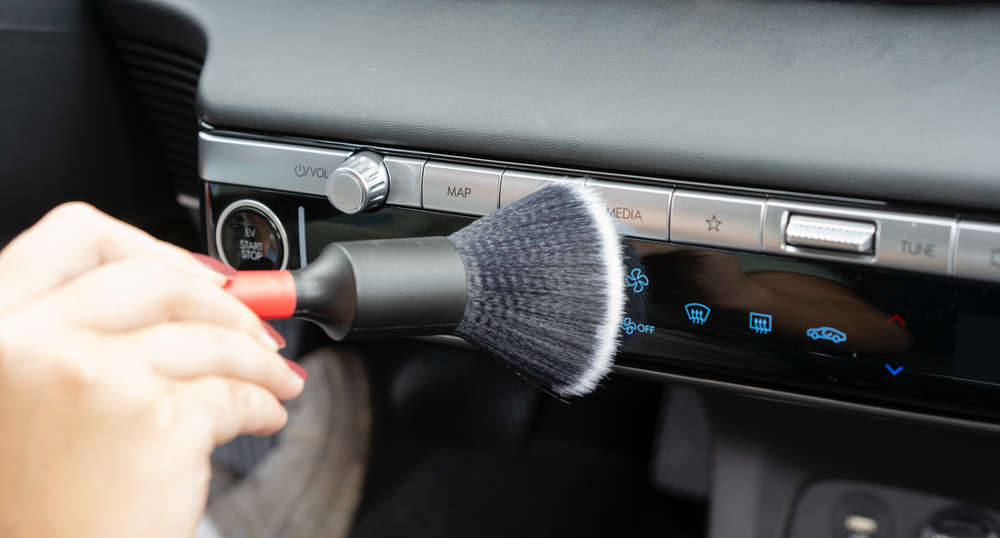Soft detailing brush cleaning precisely around vehicle dashboard controls